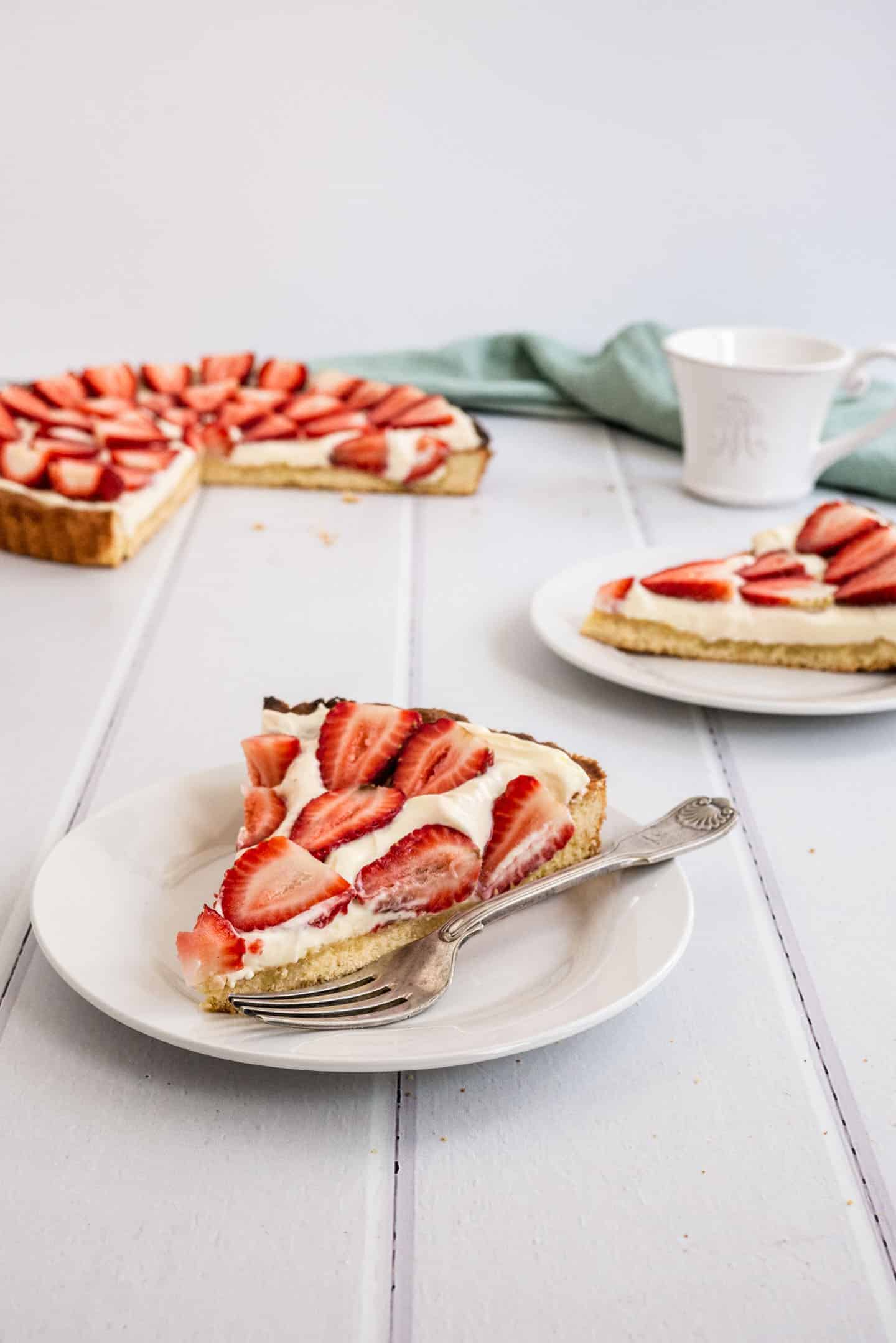 Strawberry and Cream Tart at the moment of dessert. Simple as a buttery shortbread crust, smooth creamy filling and a fresh strawberry topping.