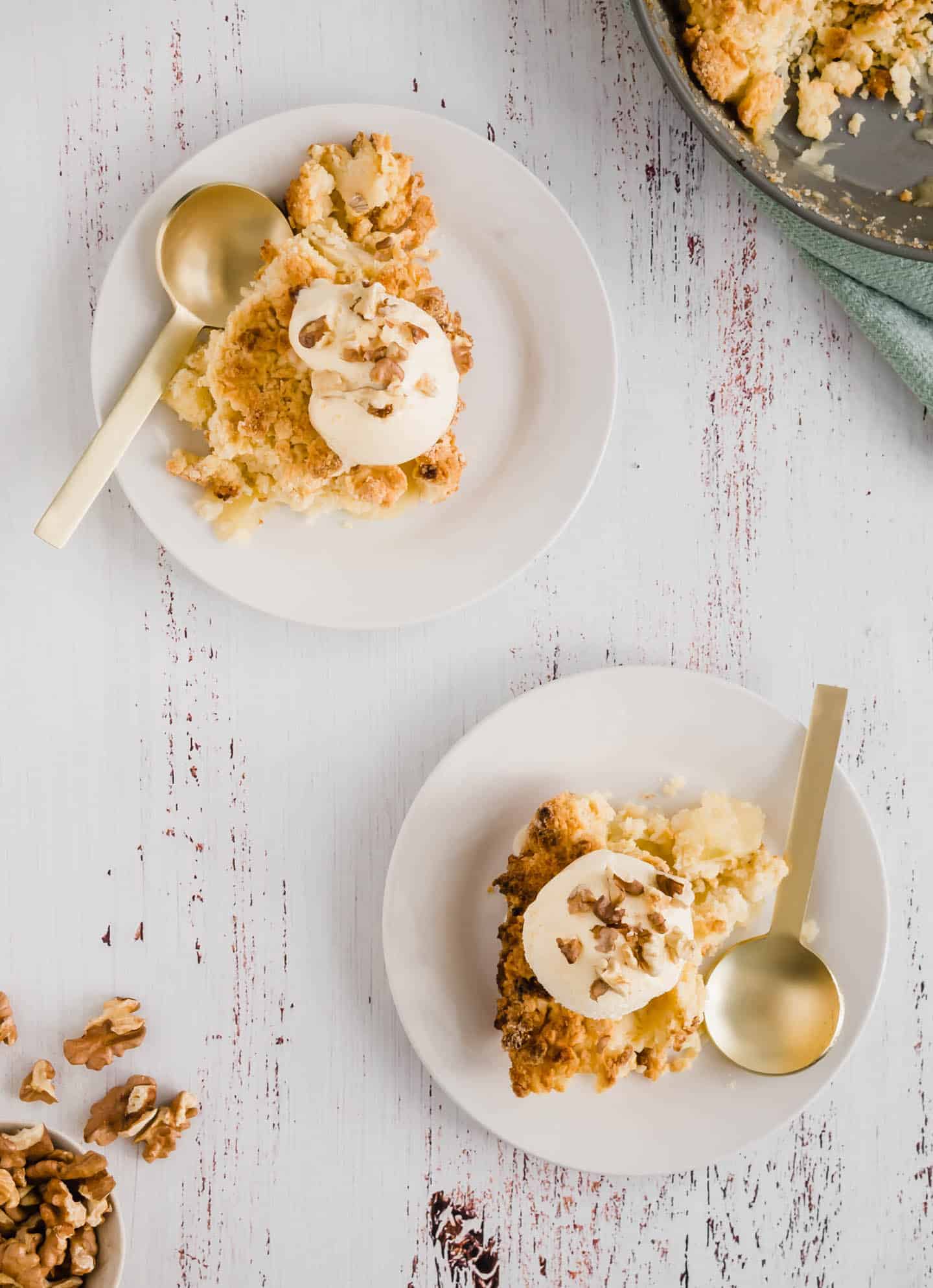 Two plates with some Apple Crumble Cake, Vanilla Ice Cream and Walnuts