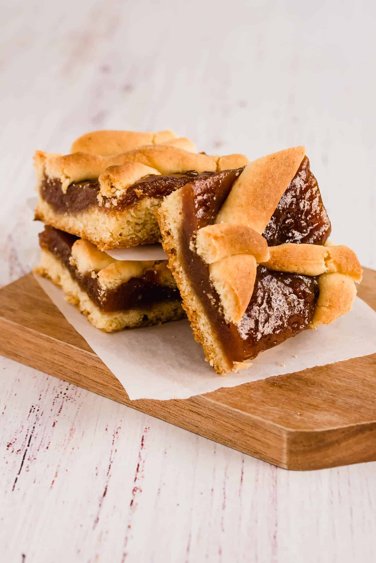 Three Pasta Frola squares on a wooden board (side)