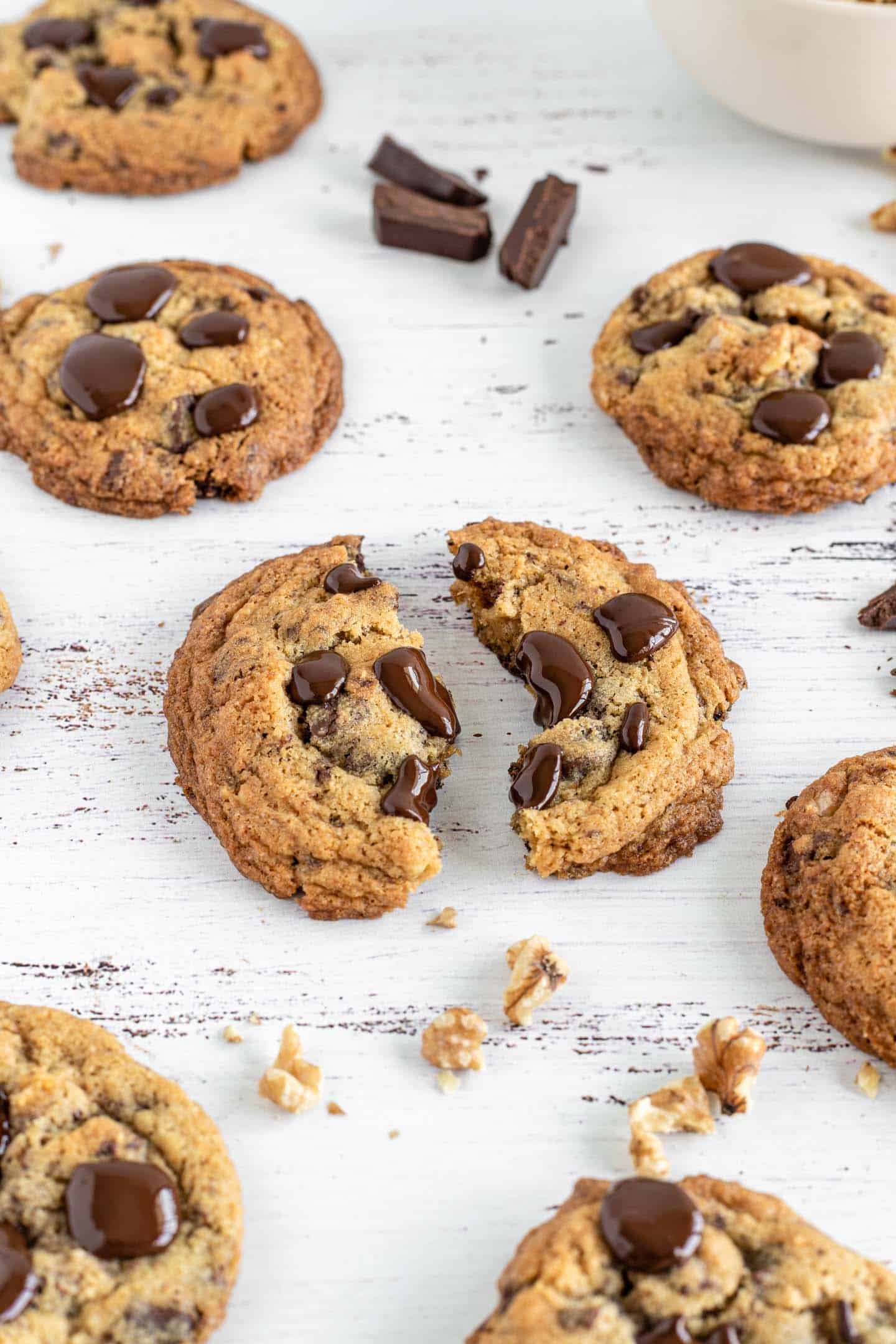 Close shot of the Walnuts and Choc Chunks Cookies on a white background A cookie cut in half