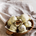 Candied walnuts covered in white chocolate and filled with dule de leche on a wooden tray