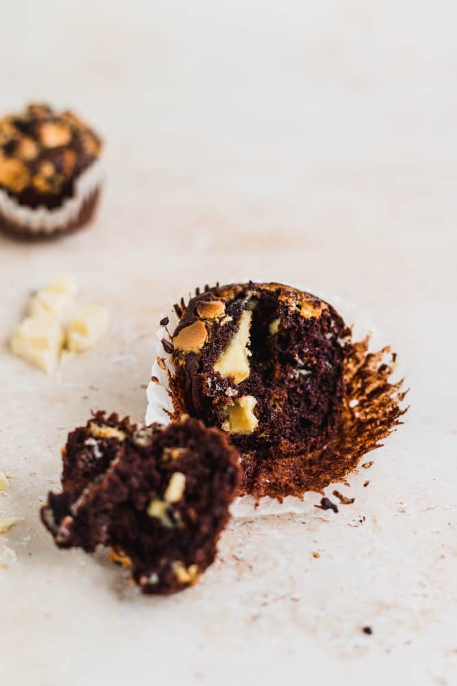 Muffin de chocolate abierto al medio y otro entero por detrás